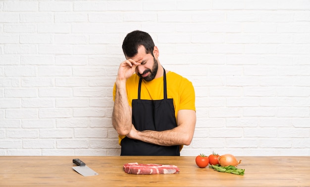 Chef sosteniendo en una cocina con expresión cansada y enferma