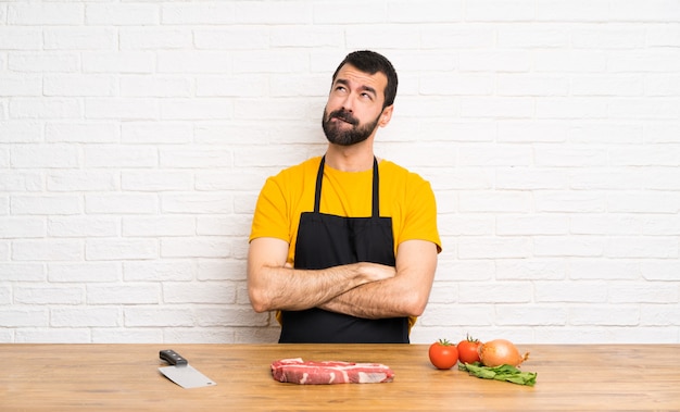 Chef sosteniendo en una cocina con expresión de la cara confusa