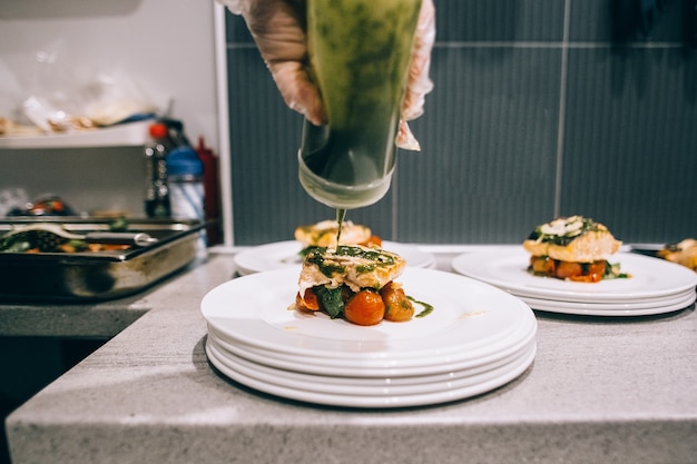 Foto chef terminando comida na cozinha de seu restaurante