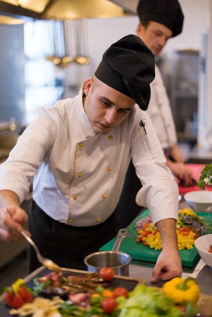 Chef terminando o prato de carne de bife com molho de prato final e quase pronto para servir à mesa