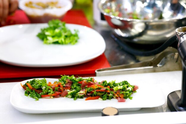 Chef terminando seu prato e quase pronto para servir à mesa Apenas mãos Finalmente prato molho de carne de bife com salada verde