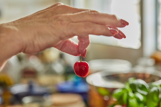 El chef toma cerezas frescas para hacer tarta.