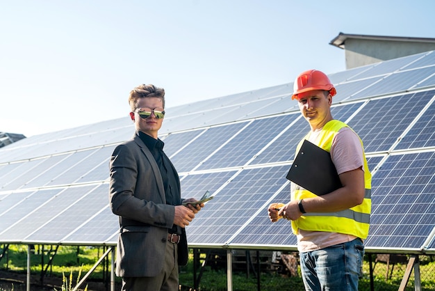 Chef und Mitarbeiter stehen in der Nähe der Solarpanels