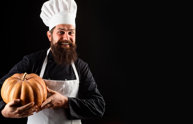 Chef en uniforme con hombre barbudo de calabaza en sombrero de chef con comida orgánica de calabaza cocinero chef en blanco