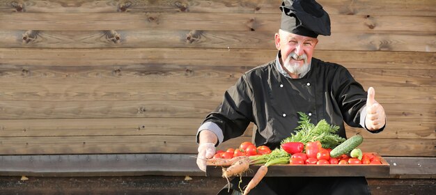 Chef viejo en uniforme con verduras