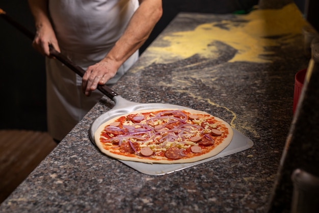 Chef de vista frontal preparando pizza