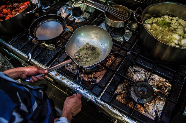 Foto chefe a cozinhar frutos do mar numa cozinha suja.