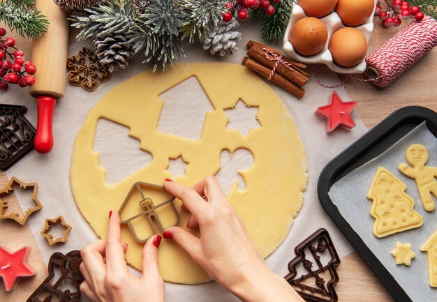 Chefe de confeitaria fazendo biscoitos de Natal usando cortadores de massa