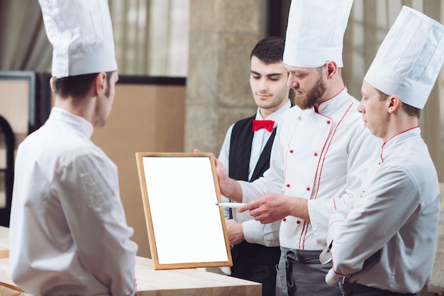 Chefe de cozinha e sua equipe na cozinha. interagindo na cozinha comercial.