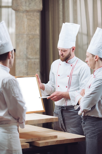 Chefe de cozinha e sua equipe na cozinha. interagindo na cozinha comercial.