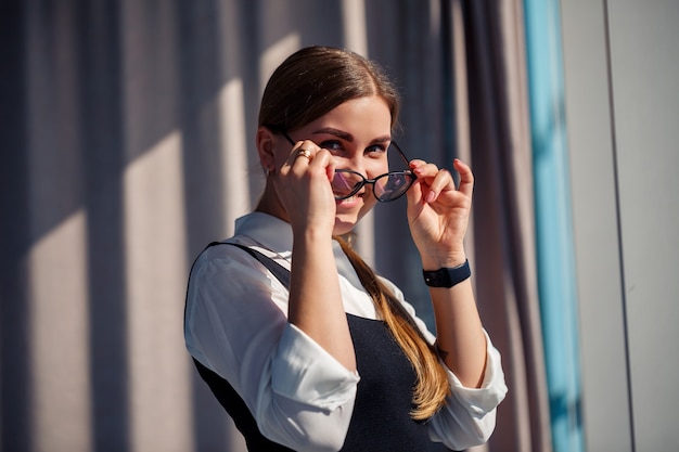 Chefe de mulher de negócios confiante em um escritório moderno usando óculos, líder feminina, proprietária de empresa, pensando no sucesso futuro, planejando novas oportunidades