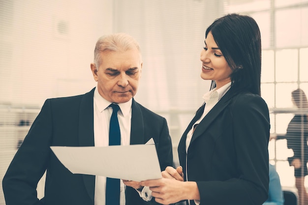 Chefe e assistente discutindo um documento comercial