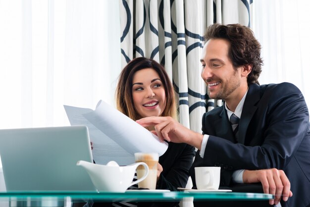 Chefe e assistente ou no hotel trabalhando juntos