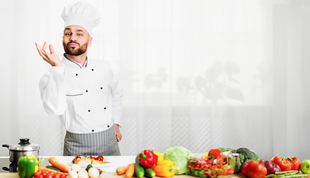 Chefe feliz fazendo gestos de aprovação do sabor de pé na cozinha do restaurante