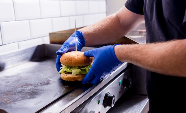 Chefkoch bereitet Burger am Küchengrillofen zu. Restaurant.