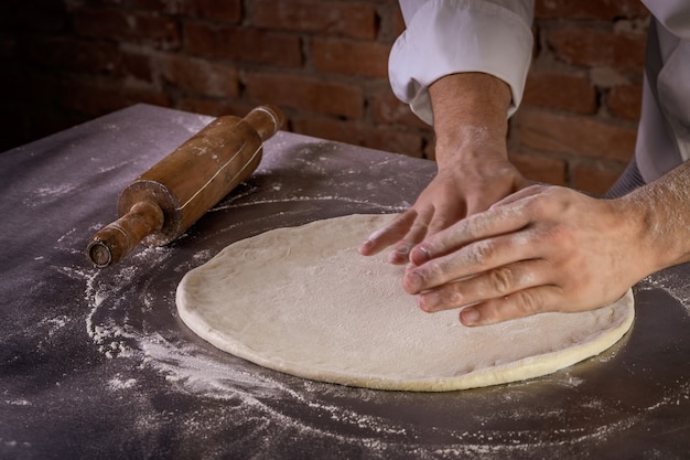 Chefkoch bereitet Pizzateig in der Küche vor