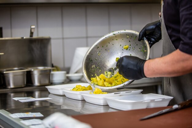 Chefkoch, der Gericht zum Mitnehmen im Restaurant oder in der Kneipe zubereitet, Essenslieferkonzept, Hauszustellung, Online-Bestellung