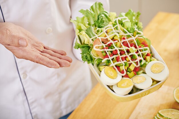 Chefkoch gibt gekleideten Salat