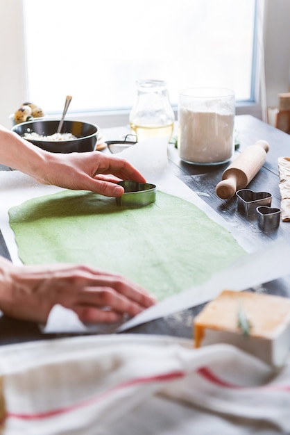 Chefkoch kocht schritt für schritt grüne ravioli in herzform für ein festliches abendessen