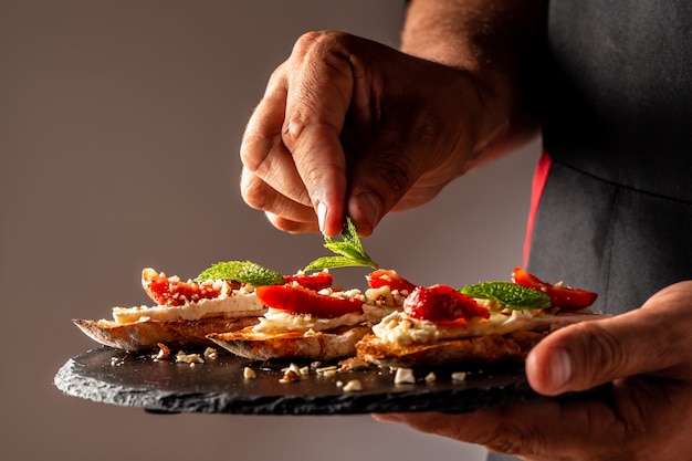 Chefkoch kocht Torten mit Sahne, Erdbeeren und Blaubeeren