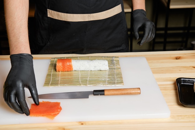 Chefkoch legte Lachs beim Zubereiten von Brötchen