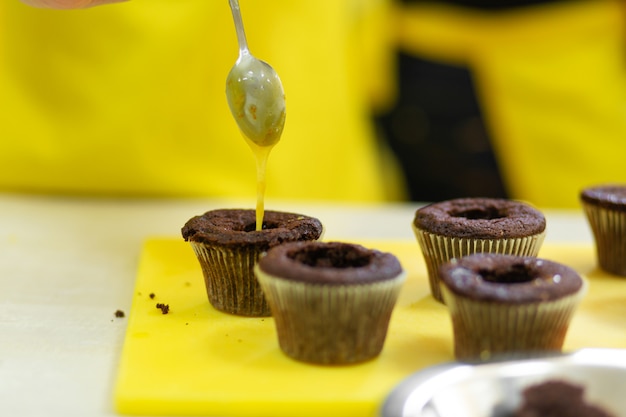 Chefkoch macht Schokoladencupcakes mit süßer Sahne