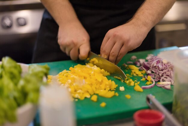 Chefkoch schneidet frisches und leckeres Gemüse zum Kochen oder Salat