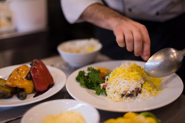 Chefkoch serviert Gemüserisotto in der Restaurantküche