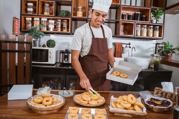 Chefkochmann, der Donuts in der Küche vorbereitet