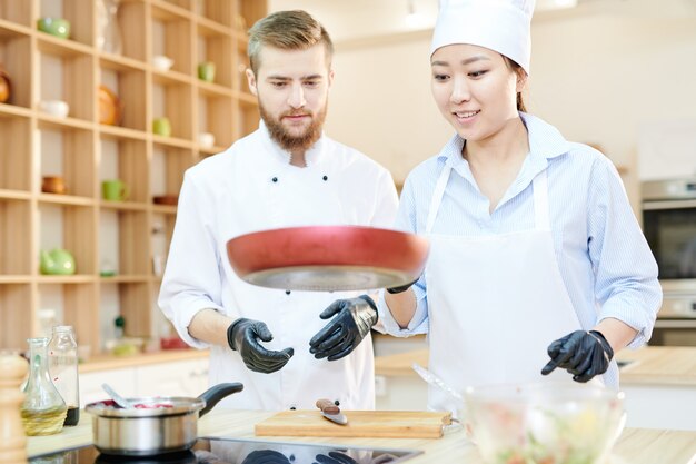 Chefs alegres trabajando en la cocina