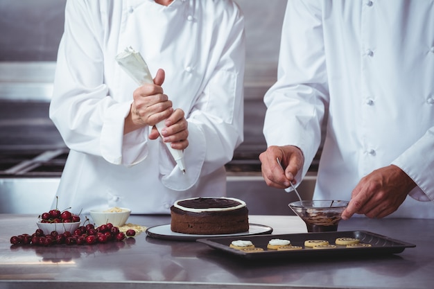 Chefs decorando um bolo