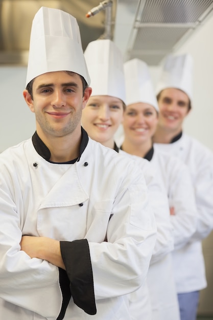 Foto chefs em linha sorrindo