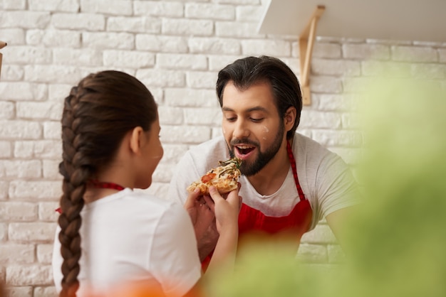 Chefs familiares están cocinando juntos con degustación de comida.