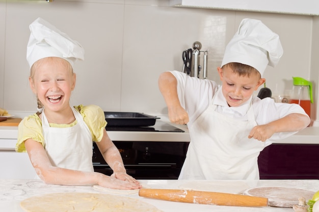 Foto chefs jóvenes muy felices preparando comida para comer en la cocina.