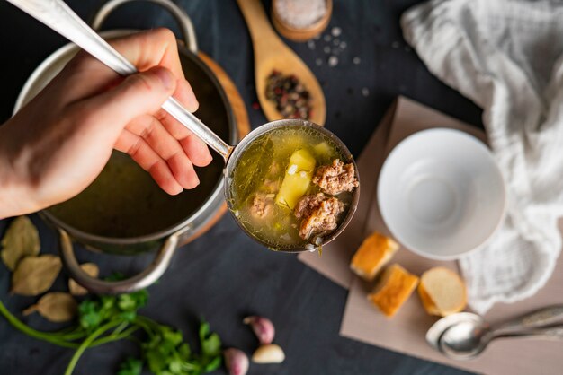 Chefs mano vierta sopa caliente fresca en un tazón vacío blanco, preparaciones de comida