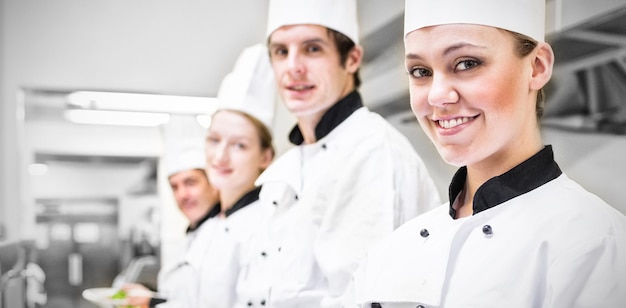 Chefs mostrando sus ensaladas en cocina comercial