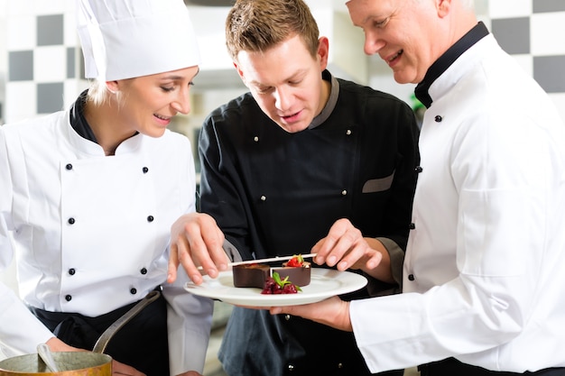 Chefteam in der Restaurantküche mit Nachtisch