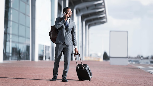 Chegando ao aeroporto Afro empresário falando no telefone