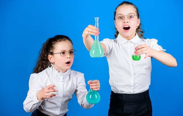 Chemie-Spaß Wissenstag Schulmädchen mit bunten chemischen Flüssigkeiten Bildungskonzept Sicherheitsmaßnahmen Kleines Kinderstudium Chemieunterricht Spaß mit Chemie haben Pädagogisches Experiment