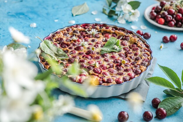 Cherry Clafoutis con cereza sobre fondo azul.