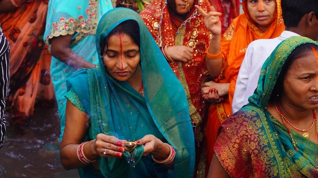 Chhath pooja celebra a las mujeres indias vestidas con ropa tradicional y de pie en el agua