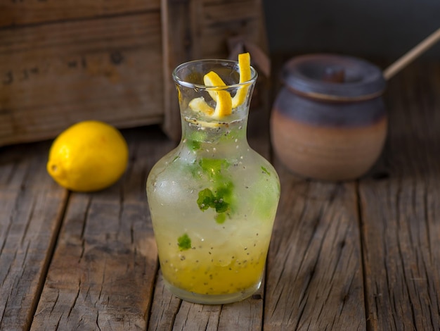 Foto chia chia saludable fresca con limón con fruta cruda servida en frasco aislado en la vista lateral de la mesa de madera