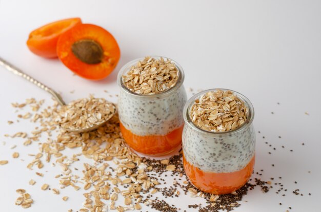 Chia Pudding des Joghurts mit frischen Aprikosen- und Haferflocken auf Weiß