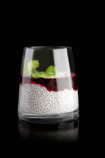 Chia-Pudding-Minze und Blaubeeren auf schwarzem Hintergrund mit Reflexion