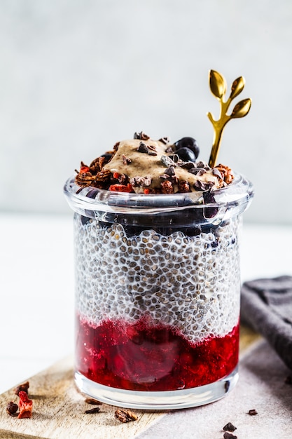 Chia-Pudding mit Beeren, Müsli und Erdnussbutter im Glas