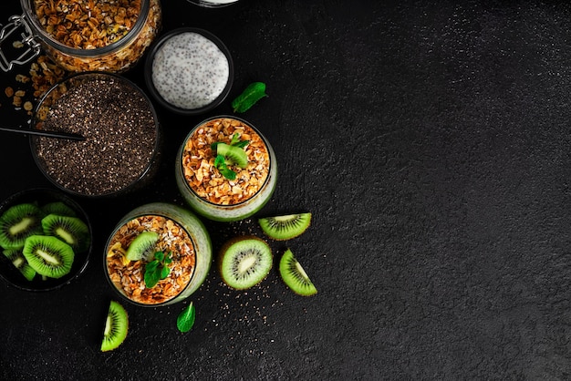 Chia-Pudding mit Kiwi und Müsli auf dunklem Hintergrund isoliert Chia-Pudding Minze und Kiwi