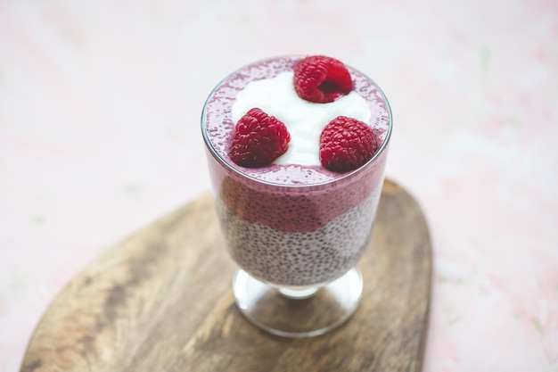 Chia Pudding mit Mandelmilch Joghurt Pitaya Pulver und Himbeeren veganes Konzept