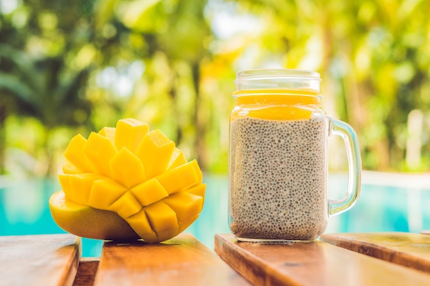 Chia-Samen-Pudding mit Mandelmilch und frischem Mango-Topping auf dem Hintergrund des Pools