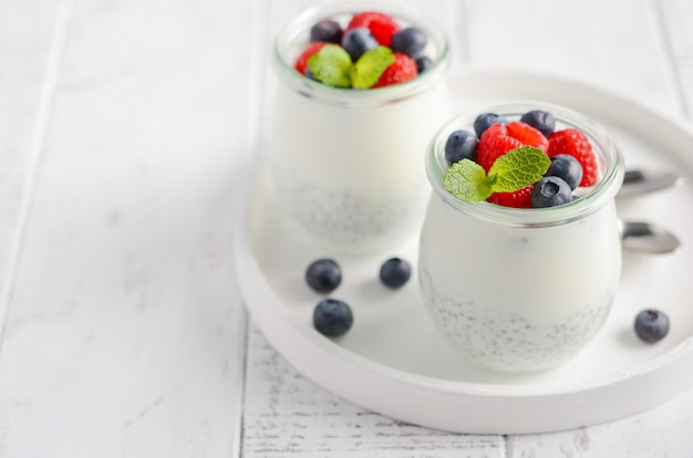 Chia-Samenpudding mit frischen Beeren auf einem weißen Holztisch