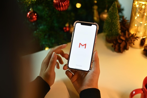 Foto chiang mai, tailândia, 31 de outubro de 2023 mulher segurando um smartphone com o logotipo do aplicativo gmail na tela